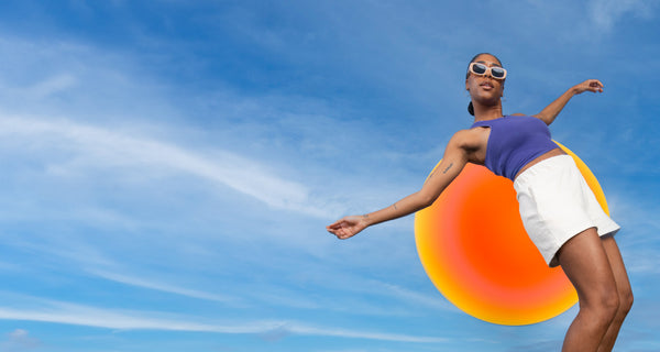 Woman on a sky backround - High SPF sunscreens | ATTITUDE