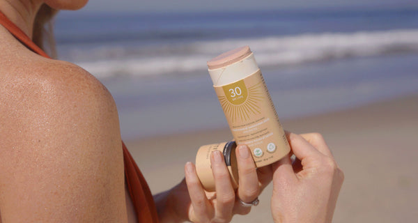 Pregnant woman applying her ATTITUDE tinted sunscreen stick while on vacation with no worries because its a safe sunscreen for pregnancy