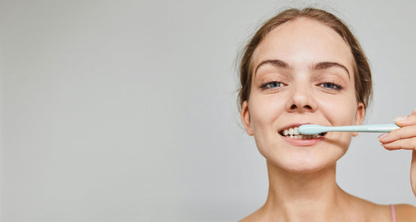 Woman brushing her teeth | Does fluoride free toothpaste benefit oral health? | ATTITUDE